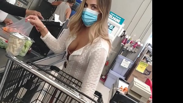 Mujer cachonda con vestido traslúcido enseñando el bikini en la tienda